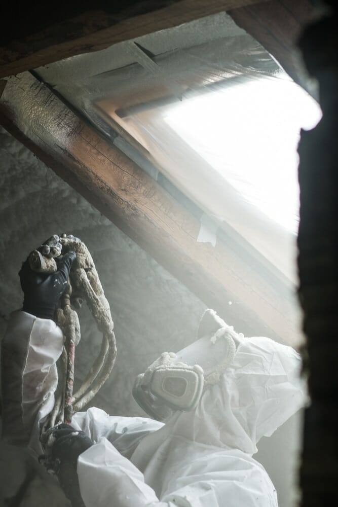 Entrepreneur en isolation polyuréthane qui pulvérise de la mousse isolante sur un entretoit à Trois-Rivières